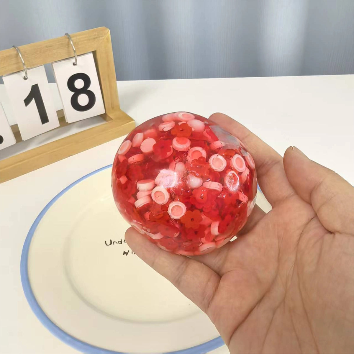 Holding the Strawberry Mochi Bloom stress ball in hand