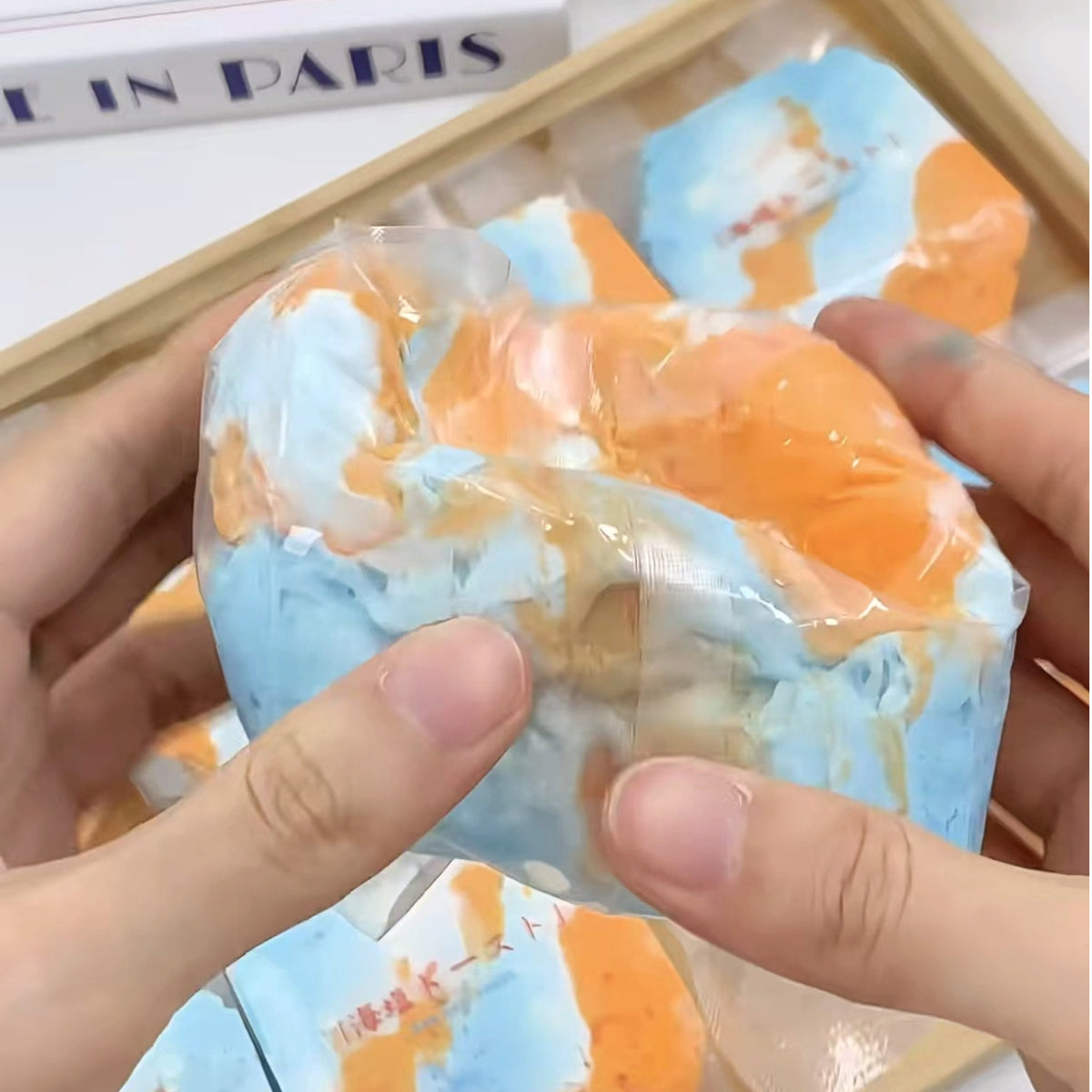 Squeezing the Orange Sea bag with both hands showing texture and flexibility